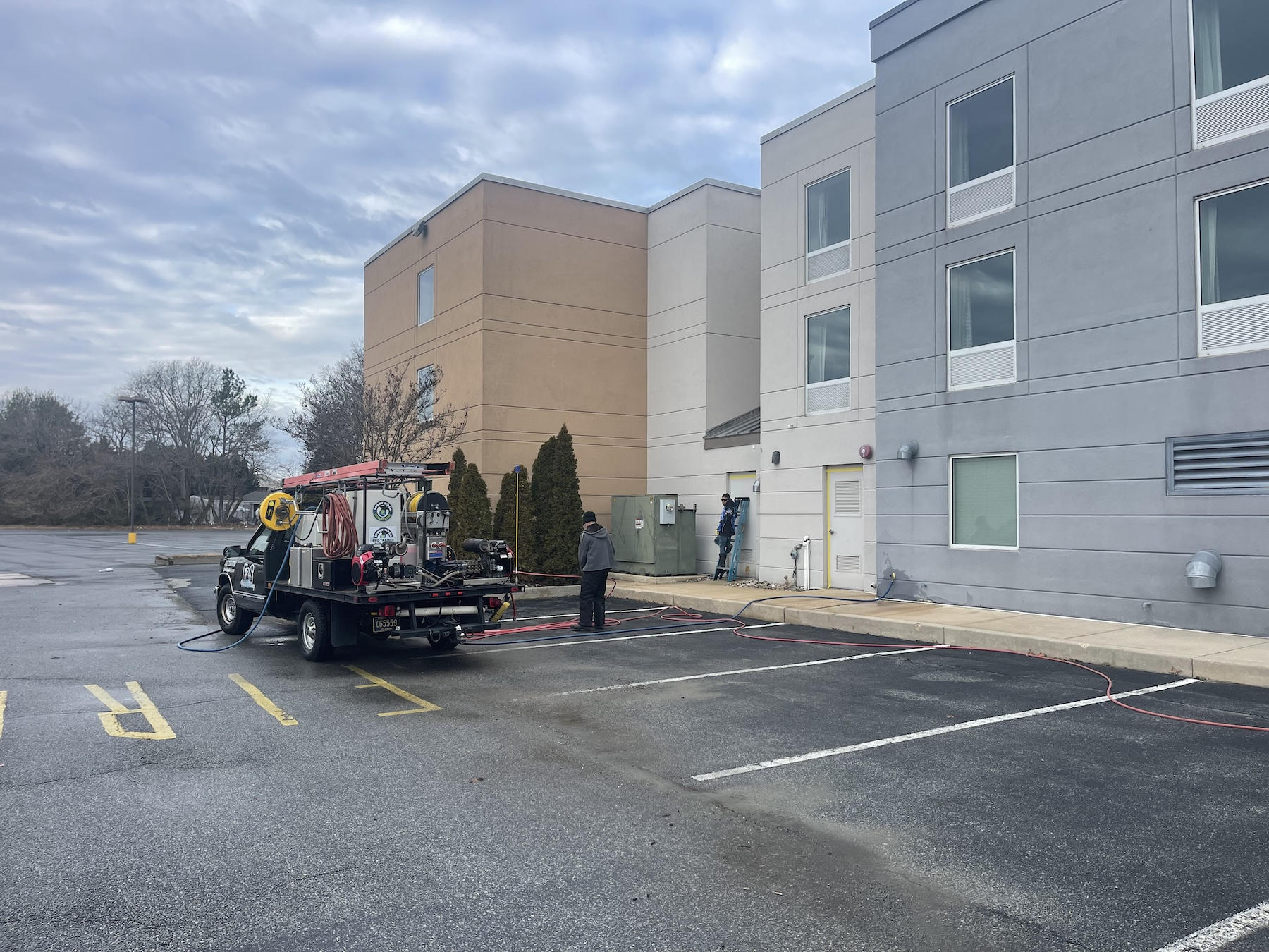 Commercial property manager supervising pressure washing services on a business exterior